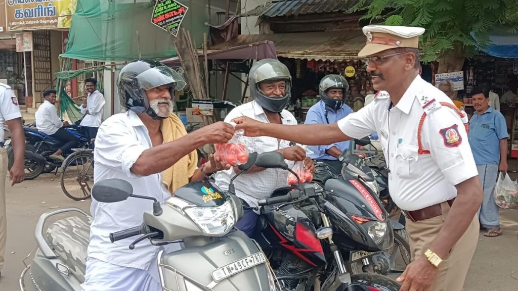 Two-wheeler riders rewarded with 1 kg of tomato for wearing helmet at Pattukottai