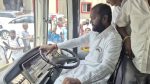 MLA sits in driver seat during bus launch ceremony.